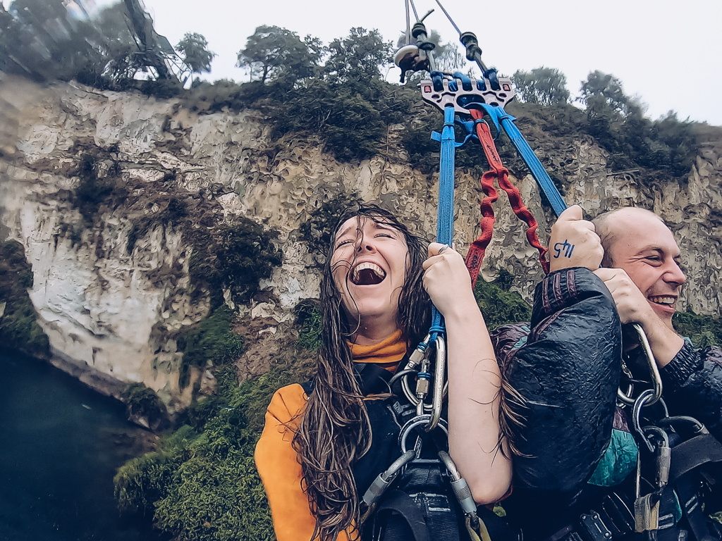 Two people on a canyon swing laughing - photo taken with a Gopro 