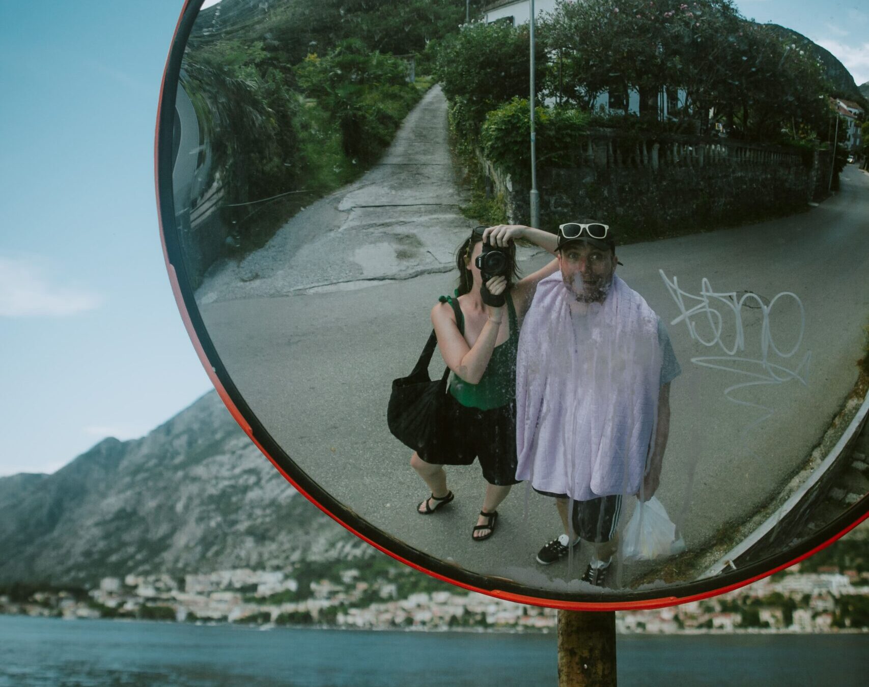 Holly taking a photo in a traffic mirror in Kotor