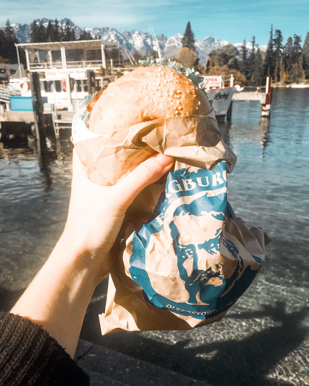 Eating a Fergburger lakeside in Queenstown 